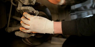 汽车修理工在一家汽车修理厂修理刹车。