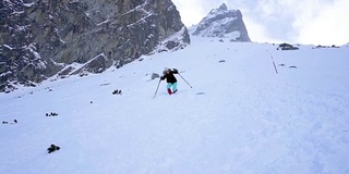 冬季在冰雪覆盖的岩石山脉中徒步旅行的慢镜头