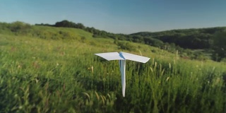 一架真正的纸飞机正飞过一个风景如画的山谷。跟随拍摄