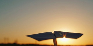 一架纸飞机在天上飞着迎接夕阳。观点视频