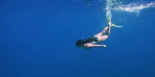 女孩在清澈的蓝色海水中潜水