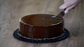 给巧克力慕斯蛋糕上釉，特写。用刀切一块巧克力蛋糕视频素材模板下载