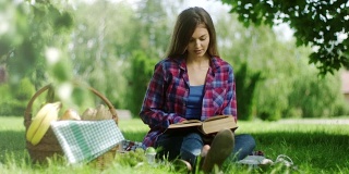 在大自然中阅读野餐书籍的女人