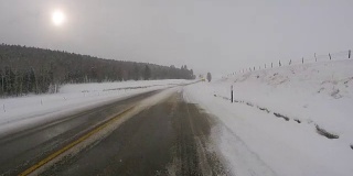 阴天冬季在冰雪覆盖的公路上驾驶