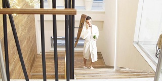 有魅力的男人花时间在水疗中心。穿着白色长袍爬楼梯