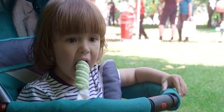 小男孩在公园的户外吃冰淇淋