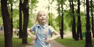 一个穿着短裤的可爱女孩正在公园里蹦蹦跳跳。