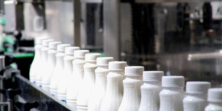 白色塑料奶瓶的连续镜头在生产线上分拣和前进的包装