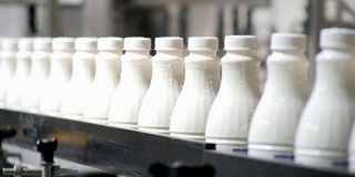 白色塑料奶瓶的连续镜头在生产线上分拣和前进的包装