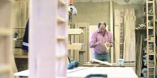 在这个小家具厂，手工工人——搬运工，用夹子把木质的细节粘在一起，做成成品。