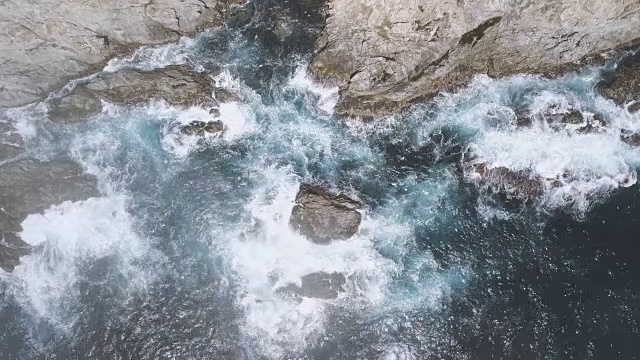 鸟瞰海浪撞击岩石海岸的照片