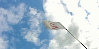 在晴朗多风的日子，明亮的多云背景上的高尔夫旗帜。