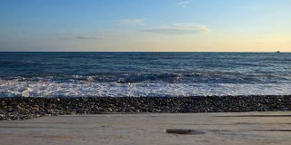 海边的沙滩用石头和卵石模糊了前面的木质平台表面。
