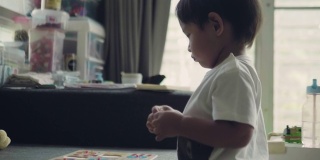 亚洲小男孩在客厅里玩木头玩具。