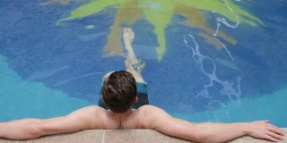 男子在泳池中放松