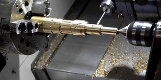 数控车床或车削机用钻具在黄铜轴上钻孔。