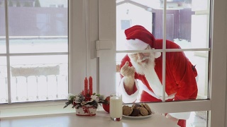 圣诞老人敲窗，想品尝牛奶和饼干视频素材模板下载