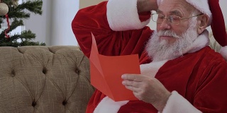 圣诞老人打开信封，开始读那封圣诞信