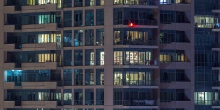 在夜晚，摩天大楼的发光窗户的时间流逝