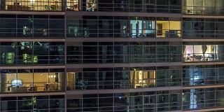 在夜晚，摩天大楼的发光窗户的时间流逝