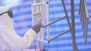 慢镜头:一个戴着防护面具、穿着工作服的成年人正在粉刷家具视频素材模板下载