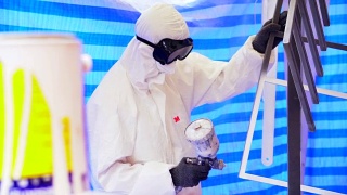 慢镜头:一个戴着防护面具、穿着工作服的成年人正在粉刷家具视频素材模板下载
