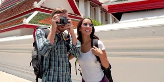 一对旅游背包客在泰国的寺庙拍照
