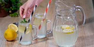 木制背景上放着两大玻璃瓶自制柠檬水