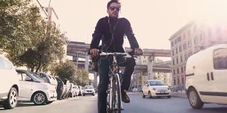 在阳光明媚的日子里，年轻的潮人骑着自行车在罗马市中心与汽车在天桥下
