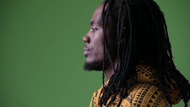 年轻英俊的非洲男子，长发绺映衬着绿色的背景