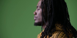 年轻英俊的非洲男子，长发绺映衬着绿色的背景