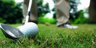 慢动作:高尔夫球手用高尔夫球杆击球
