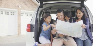 坐在车后座看地图的少数民族家庭