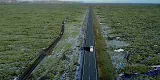 雪后的火山岩上，飞过长路青苔田。冰岛冬天的公路旅行