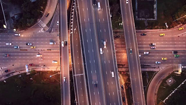 高速公路交叉口鸟瞰图，城市交通繁忙，夜间高速行驶。跨越式运输桥梁