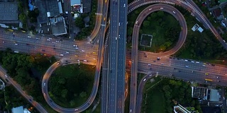 鸟瞰图无限高速公路立交桥与繁忙的城市交通在道路上加速在黄昏