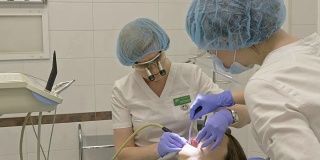 一名妇女在牙科诊所接受牙科治疗以补牙洞。牙科修复与复合材料聚合紫外光与激光。