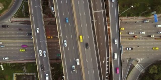 高速公路交叉口鸟瞰图与繁忙的城市交通在道路上超速行驶。跨越式运输桥梁