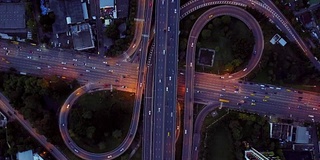 无限高速公路立交桥鸟瞰图，繁忙的城市交通在夜间高速行驶