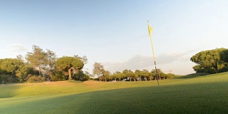 在葡萄牙南部的阿尔加维拍摄的高尔夫球场上的绿旗和洞的实时照片。