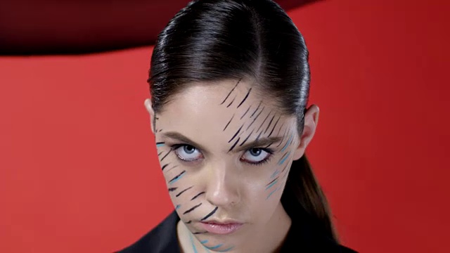 一个黑发的时尚模特的脸在透明的黑色窗帘后面的特写。时尚视频。