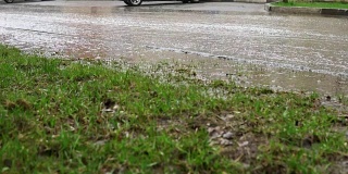 汽车在雨中行驶在被洪水淹没的道路上，慢镜头。