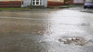 汽车在雨中行驶在被洪水淹没的道路上，慢镜头。视频素材模板下载