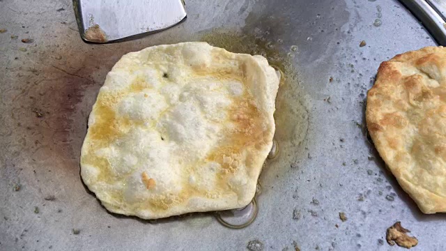 在泰国的市场上做异国风味的泰国煎饼，马来西亚烤饼。用煮熟的油在热的金属锅上煎蛋。泰国小吃。泰国甜点。