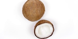 一个完整的椰子和美味的果肉旋转在白色孤立的背景。Loopable无缝