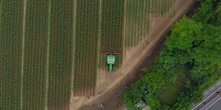 空中:拖拉机在耕地上工作，骑自行车穿越乡村