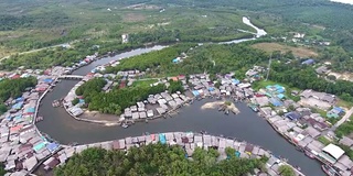 鸟瞰图，宁静的海岸村庄与弯曲的河流和海洋背景