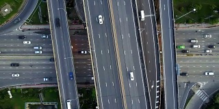 高速公路交叉口鸟瞰图与繁忙的城市交通在道路上超速行驶。跨越式运输桥梁