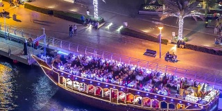 在迪拜滨海湾的旅游木船在夜晚发光的时间流逝