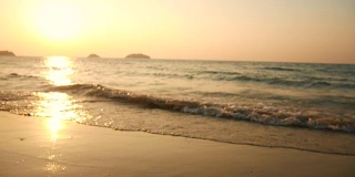 在夕阳的背景下，海滩上的海浪